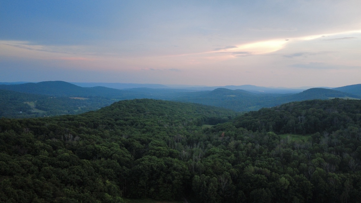 Aerial view of forested mountains at sunset