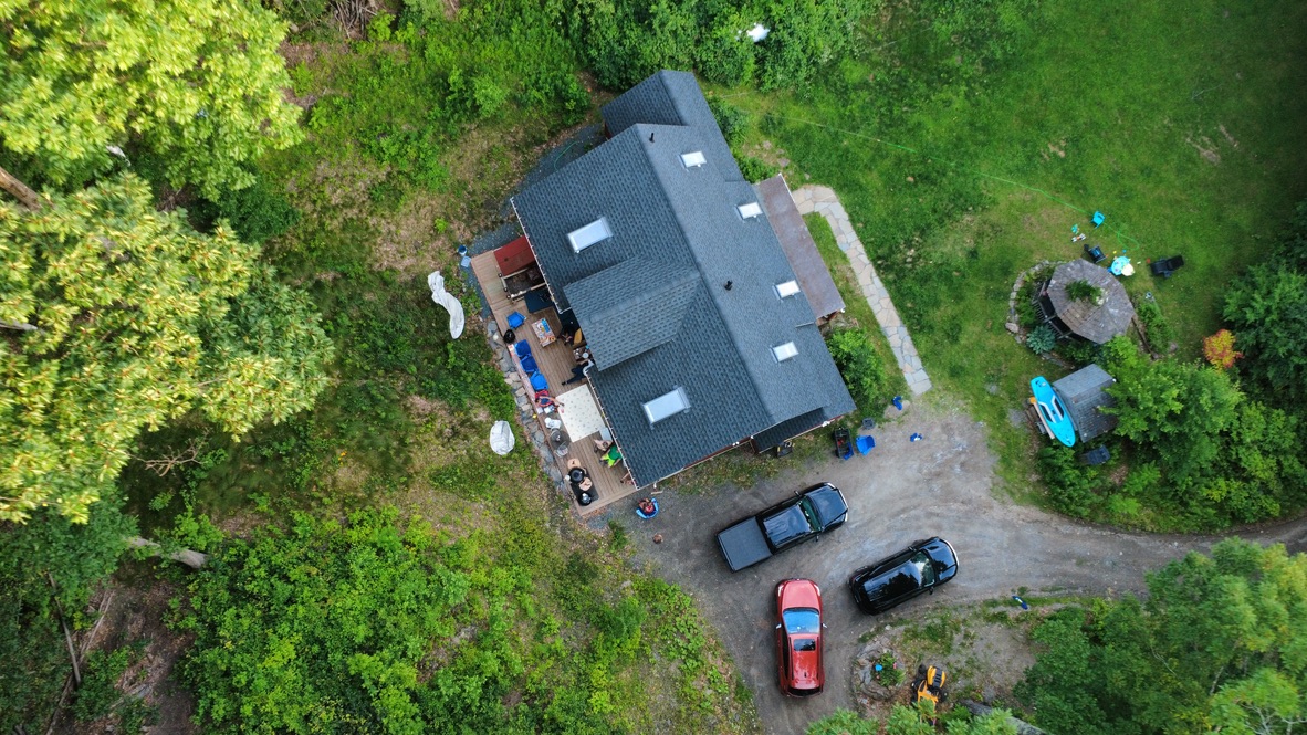 Aerial view of a house and its wooded property